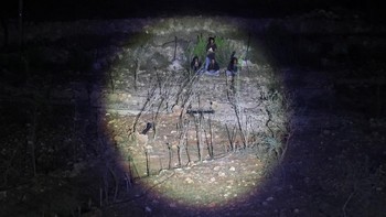 Israeli settlers are illuminated with torchlight after Palestinian-American Loui Ridi, whose home in the Israeli-occupied West Bank has been encircled by militant settlers for more than a week, returned to his besieged home, in Qusra, Israeli-occupie
