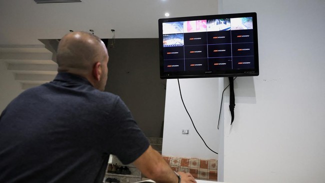 Palestinian-American Loui Ridi, whose home in the Israeli-occupied West Bank has been besieged by militant settlers for more than a week, looks at feeds from his newly installed security cameras in Qusra, in the Israeli-occupied West Bank, August 17,