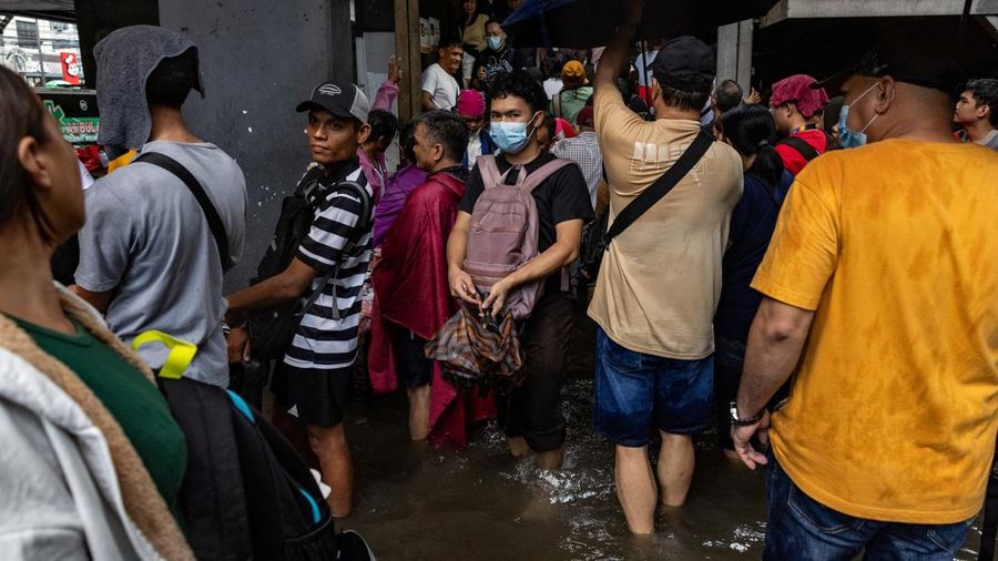 Warga menerjang banjir saat hujan deras musim monsun di Kota Manila, Filipina, Senin (17/8/2026). (REUTERS/Eloisa Lopez)