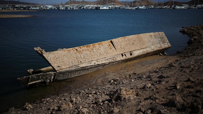 A surfaced boat is visible along the shoreline of Lake Mead, the largest reservoir in the United States by water capacity, highlighting the long-term effects of drought and water demand on the Colorado River system, near Boulder City, Nevada, U.S., A
