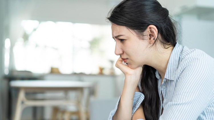 Asian beautiful unhappy woman sit on sofa feel frustrated and stressed&period; Attractive worried female having psychological problem feeling anxiety depression&comma; upset and grief troubled for health at home&period;