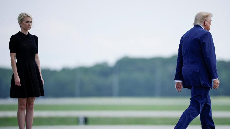 U.S. President Trump walks by his Executive assistant Natalie Harp as they attend a dignified transfer of the remains of U.S. Army service members, Army 1st Lt Tyler James Feehan, Sgt. Angel S. Rampersad, Pvt. Isabella Gonzales, killed during an atta