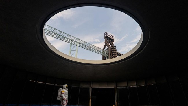 An astronaut figure stands beneath a circular roof opening at the Shou - Wang Tian Gong Beijing Space Exploration Center in Beijing's Shougang Park, China, August 7, 2026. Once highly classified in remote deserts, China's space launches have increasi