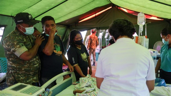 A family grieves for a woman who passed away in the makeshift hospital tent outside a damaged hospital, in the aftermath of an earthquake in Nagekeo, East Nusa Tenggara, Indonesia, August 17, 2026. REUTERS/Edgar Su