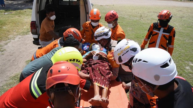 This handout picture taken and released on August 19, 2026 by Indonesia's Search and Rescue Agency (BASARNAS) shows rescue personnel moving a person on a stretcher into a vehicle for evacuation in East Manggarai, following a 7.7-magnitude earthquake