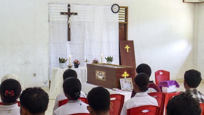 Relatives pray for Leonardus Noprianto Waku, a victim of the Flores earthquake, as it lies in state at the Chapel of St. Peter's Major Seminary Ritapiret in Maumere, East Nusa Tenggara on August 19, 2026, after the victim had previously received trea