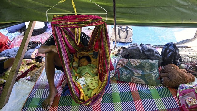 A one-month old baby sleeps in a tent in an open field in Marapokot, Nagekeo, East Nusa Tenggara, on August 17, 2026, following a 7.7-magnitude earthquake. Thousands of people displaced by a powerful earthquake in eastern Indonesia awaited much-neede