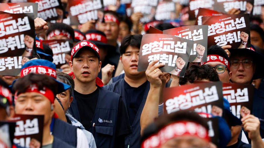 Anggota Serikat Pekerja Logam Korea memegang plakat nan menuntut perundingan berbareng secara langsung dengan kontraktor utama dalam sebuah unjuk rasa di luar instansi pusat Hyundai Motor Company, saat serikat pekerja perusahaan otomotif tersebut menggelar pemogokan kerja total pertamanya dalam satu dasawarsa terakhir, di Seoul, Korea Selatan, pada 21 Agustus 2026.