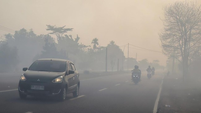 Asap karhutla menyelimuti permukiman di sepanjang tepi Sungai Kahayan di Palangkaraya, Kalimantan Tengah, Jumat (21/8).