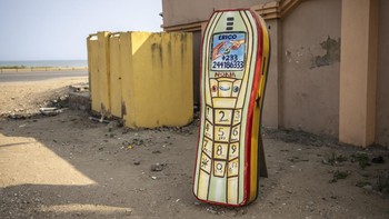 A mobile phone-shaped coffin, designed in reference to the profession of the deceased, a phone shop owner, is pictured at the Erico Carpentry Shop in Accra, on August 17, 2026. Fantasy coffins are a distinctive Ghanaian funerary tradition, particular