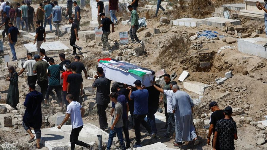 Warga Palestina mengusung peti jenazah saat menghadiri pemakaman 50 orang dari tiga family nan tewas dalam perang dan jenazahnya baru-baru ini dievakuasi dari bawah reruntuhan, di Kota Gaza, 20 Agustus 2026. (REUTERS/Mahmoud Issa)