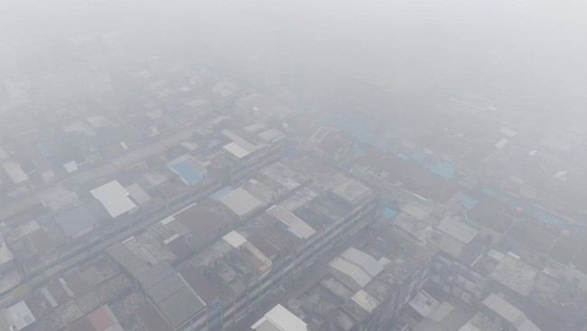Foto udara kawasan pemukiman Seberang Ilir yang tertutup kabut asap di Kota Palembang, Sumatera Selatan, Minggu (23/8/2026). Berdasarkan citra satelit Himawari-9 yang dipantau BMKG pada Minggu (23/8) pukul 10:00 WIB, terdeteksi terjadi sebaran asap d