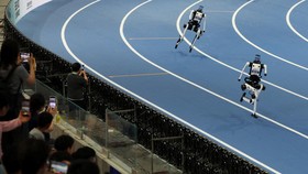 Spectators watch as Tiangong Ultra humanoid robots compete in a 400m large-size group race, during the second World Humanoid Robot Games at the National Speed Skating Oval in Beijing, China August 23, 2026. REUTERS/Florence Lo