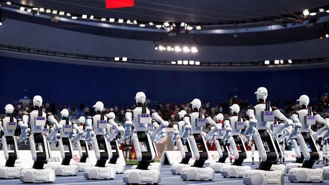 Galbot humanoid robots face a Chinese national flag during the national anthem at the opening ceremony of the 2026 World Humanoid Robot Games, at the National Speed Skating Oval, in Beijing, China August 22, 2026. REUTERS/Tingshu Wang