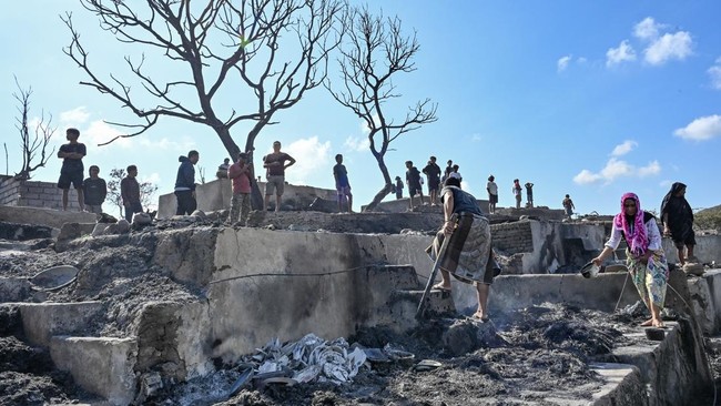 Warga mengais puing sisa barang-barang mereka yang terbakar di Desa Adat Sade, Rembitan, Kecamatan Pujut, Praya, Lombok Tengah, NTB, Minggu (23/8/2026). Kebakaran yang terjadi sekitar pukul 20.00 Wita Minggu (22/8) menghanguskan 120 bangunan di Desa