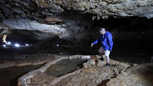 Brian Lewarne from the UK, inserts a temperature probe into the water while inspecting a specimen of the rare cave-dwelling amphibian (Proteus anguinus) inside Vjetrenica Cave, a UNESCO World Heritage Site, as the Balkans endure repeated summer heatw