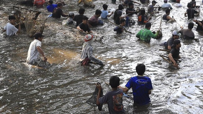 Sejumlah warga menangkap ikan saat tradisi Grobyak Ikan di Sumber Gundi, Kabupaten Kediri, Jawa Timur, Minggu (23/8/2026). Tradisi memanen ikan hanya sekali dalam setahun tersebut merupakan cara warga sekitar mensyukuri aliran mata air yang tidak per