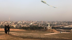 Palestinian children fly a kite in Rafah in the southern Gaza Strip on March 30, 2024 amid the ongoing conflict in the Palestinian territory between Israel and the militant group Hamas (Photo by MOHAMMED ABED / AFP)