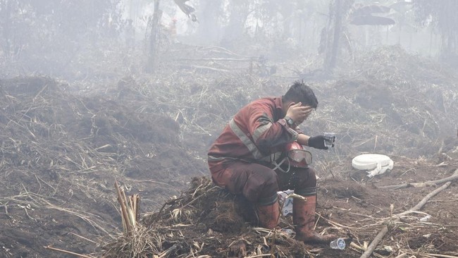 Personel Manggala Agni Daops Pekanbaru yang kelelahan membasuh muka dengan air saat berupaya melakukan pemadaman lahan yang terbakar di Desa Rimbo Panjang, Kecamatan Tambang, Kabupaten Kampar, Riau, Senin (24/8/2026). Pemerintah terus berupaya melaku