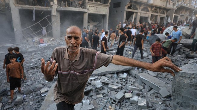 A man gestures as Palestinians inspect the site of an Israeli strike on a house, carried out after the Israeli military warned residents to evacuate the area, at al-Shati (Beach) refugee camp, in Gaza City, August 24, 2026. REUTERS/Dawoud Abu Alkas