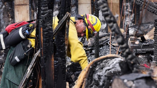 Fire crews remain on scene at a home destroyed after tens of thousands of people were evacuated over the weekend and many others were prepared to leave as the Hawk wildfire threatened north Reno, Nevada, U.S., August 24, 2026. REUTERS/Emily Najera
