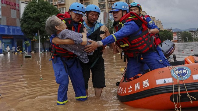 Rescue workers carry an elderly person as they evacuate residents by boat after heavy rainfall brought by typhoon Narra caused flooding in Ningming county, Chongzuo, Guangxi Zhuang Autonomous Region, China, August 24, 2026.  cnsphoto via REUTERS ATTE