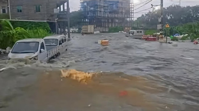 Vehicles lie partially submerged on a flooded street, seen through the windshield of a vehicle, in the aftermath of floods caused by tropical cyclone Gaenari in Jinjiang, Fujian Province, China, in this still image from a social media video released