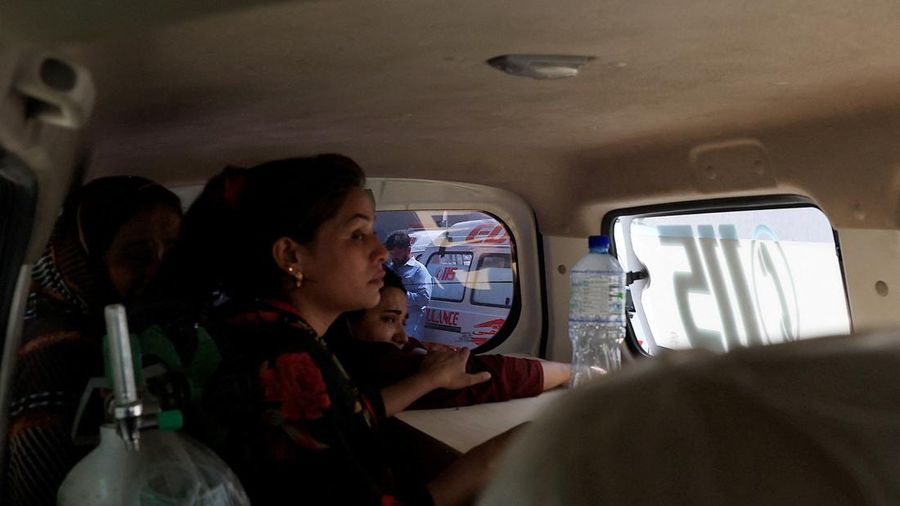 Javeria, ibu dari seorang bayi nan menjadi korban, memeluk peti jenazah berisi jasad bayinya di dalam ambulans setelah kebakaran maut di rumah sakit Pakistan Institute of Medical Sciences (PIMS) di Islamabad, Pakistan, pada 26 Agustus 2026.