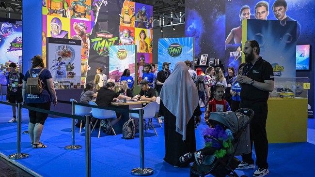 Visitors stand at the Paramount video games booth during the Gamescom video games trade fair at the Trade Fair Center in Cologne, western Germany, on the first day of the fair on August 20, 2025. The 2025 edition of the vast Gamescom trade fair in Co