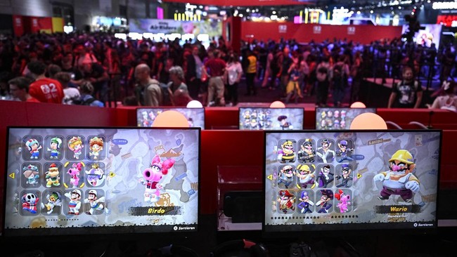 Gamers play at the Nintendo booth during the Gamescom video games trade fair at the Trade Fair Center in Cologne, western Germany, on August 21, 2025. The 2025 edition of the vast Gamescom trade fair in Cologne, Germany, had its opening night on Augu
