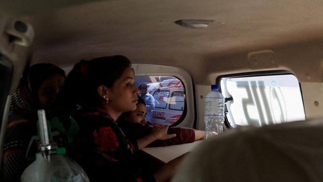 Javeria, mother of a newborn victim, holds onto a coffin containing the body of her newborn inside an ambulance following a deadly fire at the Pakistan Institute of Medical Sciences (PIMS) hospital in Islamabad, Pakistan, August 26, 2026. REUTERS/Akh