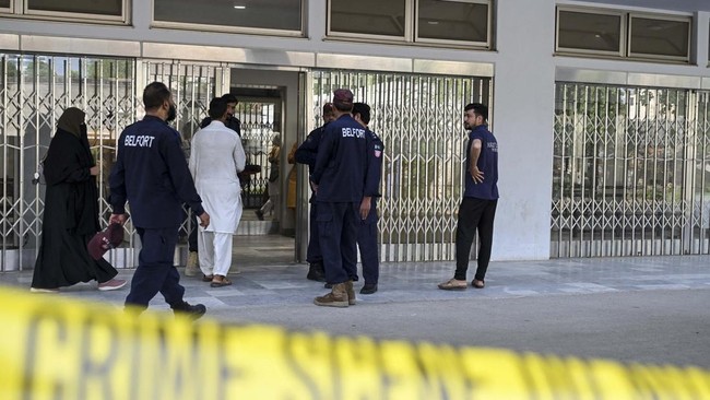 Patients arrive as private security personnel stand outside the Mother and Child Health ward of the Pakistan Institute of Medical Sciences (PIMS) Hospital, a day after a fire incident in Islamabad on August 27, 2026. A fire erupted in a hospital mate