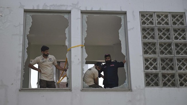 Police look on from shattered windows at the scene following a fire outside the Mother and Child Health (MCH) ward at the Pakistan Institute of Medical Sciences (PIMS) Hospital in Islamabad on August 26, 2026. A fire in a maternity ward at a public h
