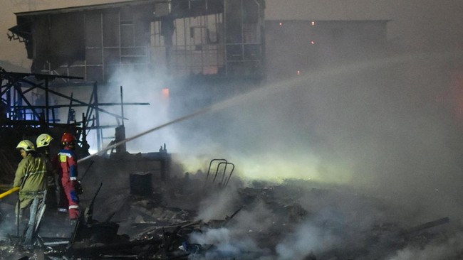 Petugas Suku Dinas Penanggulangan Kebakaran dan Penyelamatan (Sudin Gulkarmat) melakukan pendinginan saat kebakaran rumah semi permanen di Muara Angke, Jakarta, Rabu (26/8/2026). Sebanyak 22 unit mobil dengan 110 personel Sudin Gulkarmat dikerahkan u