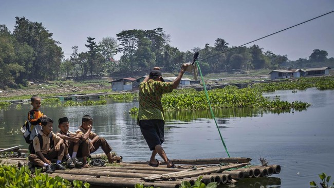 Sejumlah siswa SDN Budiharja menyeberangi perairan Waduk Saguling menggunakan rakit di Cililin, Kabupaten Bandung Barat, Jawa Barat, Jumat (28/8/2026). Sejumlah siswa dan warga dari Kampung Sadang serta Kampung Gombong sejak tahun 1990 terpaksa menye