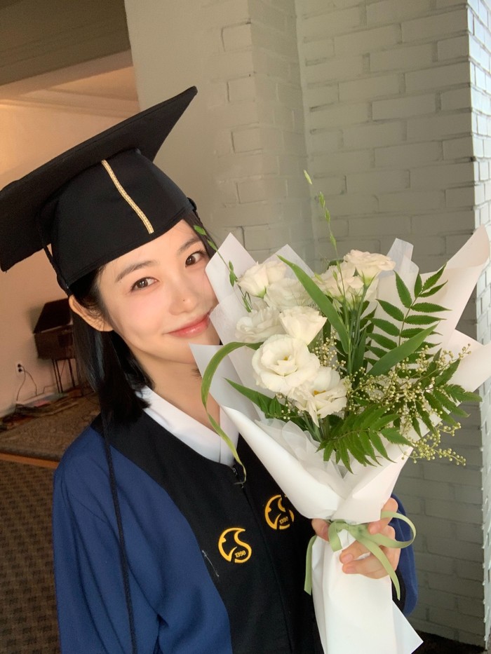 Dalam postingan tersebut, Shin Ye Eun tampil menawan dengan toga wisuda lengkap sambil memegang kue dan buket bunga./ Foto: instagram.com/__shinyeeun