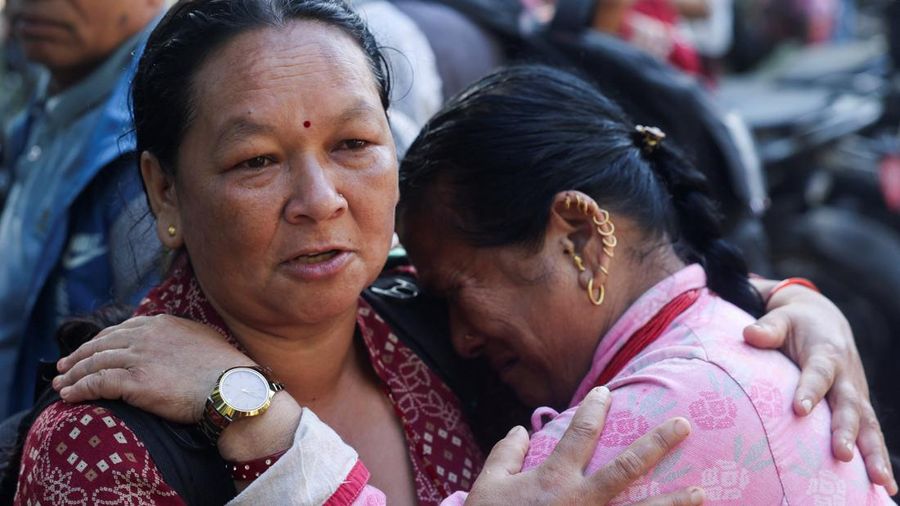 Kalpana Rimal, nan melangkah kaki dari distrik Rasuwa, menghibur seorang wanita nan rumahnya juga terdampak banjir bandang dan tanah longsor, di luar pusat training militer Maithali Barrack di Nuwakot, Nepal, pada 28 Agustus 2026.