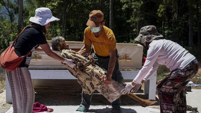 Relatives clean the remains of Ester Matasik Sarunnu after they are removed from the burial chamber during Ma'nene, a Torajan ritual where families exhume, clean and redress their deceased relatives to honour them, in Pangala, North Toraja, South Sul