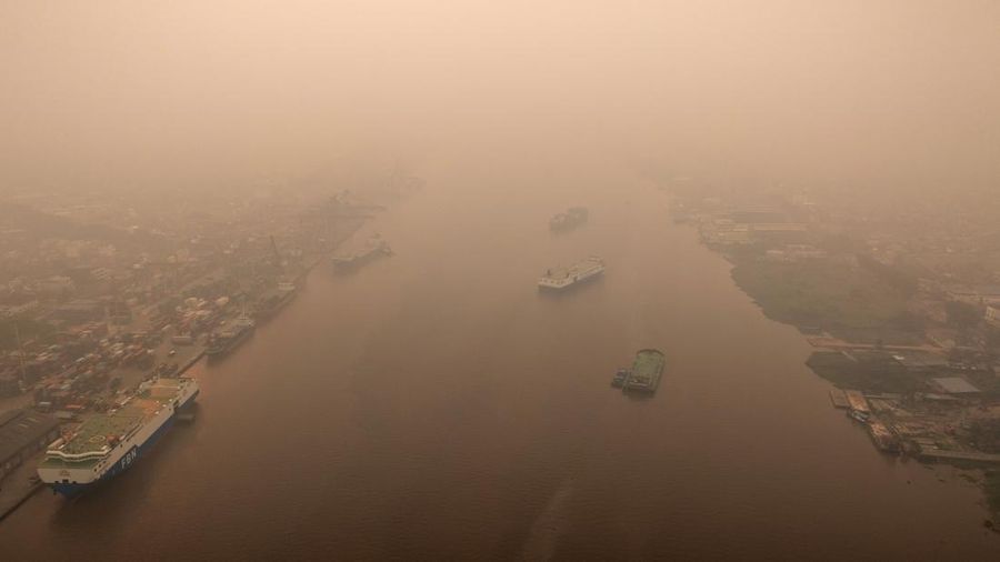 Tampilan dari drone nan memperlihatkan kapal-kapal di Sungai Kapuas saat kabut asap akibat kebakaran rimba menyelimuti wilayah tersebut di Pontianak, Provinsi Kalimantan Barat, Indonesia, pada 27 Agustus 2026. (REUTERS/Willy Kurniawan)
