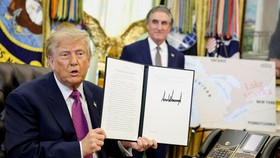 U.S. President Donald Trump holds up an executive order to rename Lake Ontario as Lake America after signing it at the Oval Office of the White House in Washington, D.C., U.S., August 27, 2026. REUTERS/Evan Vucci