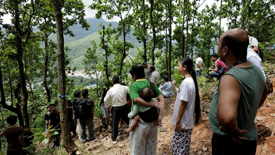 Warga berdiri di atas bukit setelah mencapai dataran tinggi menyusul peringatan bahwa tanggul waduk telah jebol, dua hari setelah banjir bandang dan tanah longsor di Trishuli, distrik Nuwakot, Nepal, pada 28 Agustus 2026.