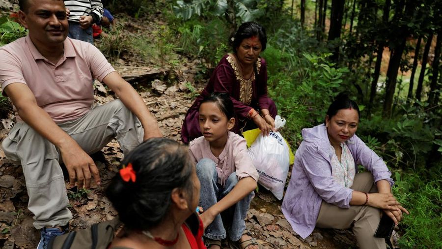 Warga duduk di atas bukit setelah mencapai dataran tinggi menyusul peringatan bahwa tanggul waduk telah jebol, dua hari setelah banjir bandang dan tanah longsor di Trishuli, distrik Nuwakot, Nepal, pada 28 Agustus 2026.