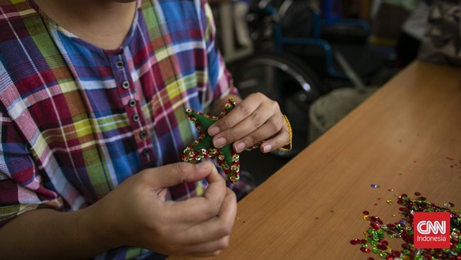 Seorang penyandang disabilitas memproduksi kerajinans di rumah produksi milik Yayasan Wisma Chesire, Cilandak, Jakarta. Produksi kerajinan di rumah produksi tersebut bertujuan memberdayakan sekaligus meningkatkan keterampilan para penyandang disabili