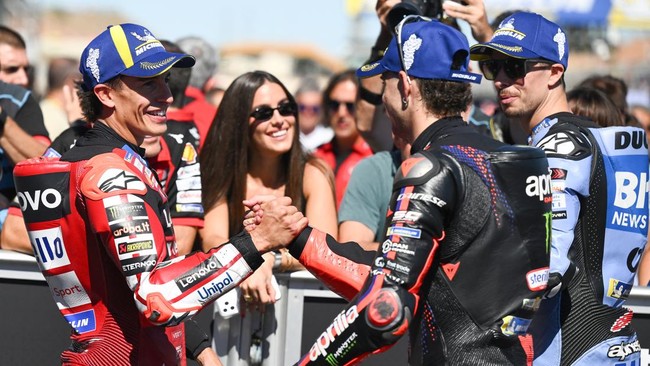 Team Aprilia Racing's Marco Bezzecchi (C) is congratulated by Team Ducati Lenovo Team's Marc Marquez (L) and Team Gresini Racing MotoGP's Alex Marquez for winning the qualifying session of the MotoGP Aragon Grand Prix at the Motorland circuit in Alca