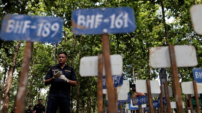 A police officer stands near identification number tags for bodies at the Devghat mass burial site for victims of deadly flash floods and mudslides, in Chitwan, Nepal, August 30, 2026. REUTERS/Navesh Chitrakar     TPX IMAGES OF THE DAY
