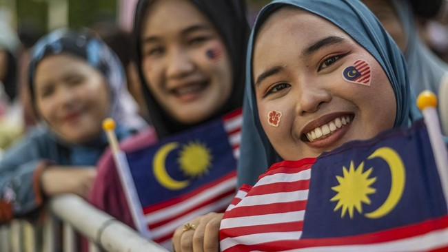 A woman with her face painted with the Malaysian flag poses for pictures during the 69th National Day celebrations in Malaysias administrative capital Putrajaya on August 31, 2026. The country is commemorating the anniversary of the independence of t