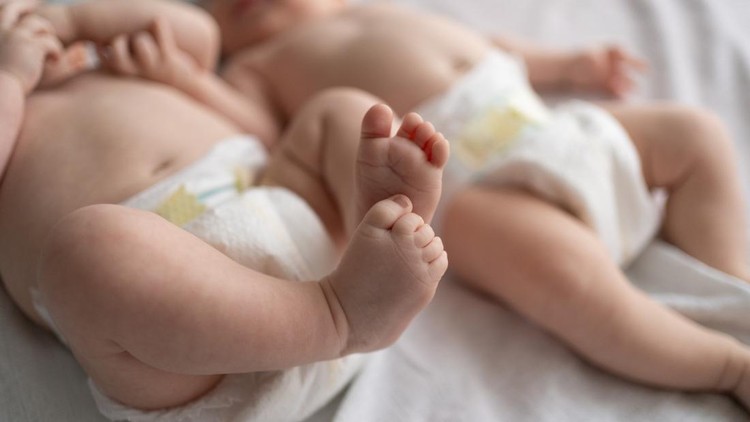 Feet of baby twins lying in bed