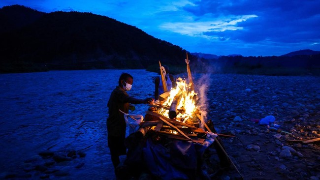 A relative of Prabita Roila, 32, who lost her life following deadly flash floods and a mudslide, lights her funeral pyre at the Suryamati River in Trishuli, Nuwakot district, Nepal, August 30, 2026. REUTERS/Athit Perawongmetha
