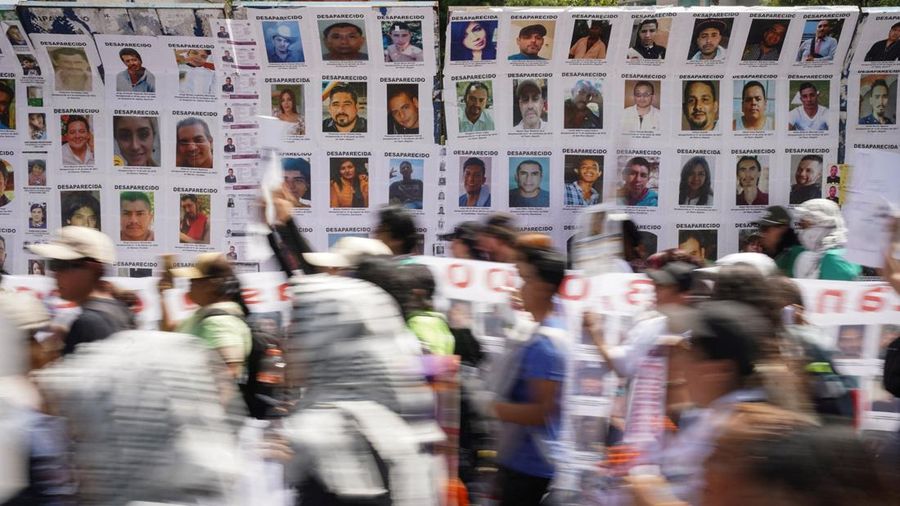 Orang-orang melangkah melewati poster orang-orang nan lenyap dalam sebuah unjuk rasa untuk memperingati Hari Internasional Korban Penghilangan Paksa di Mexico City, Meksiko, pada 30 Agustus 2026.