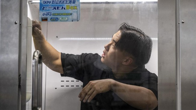 Konoe employee Taichi Konishi takes a break in a cooling box for workers also known as a